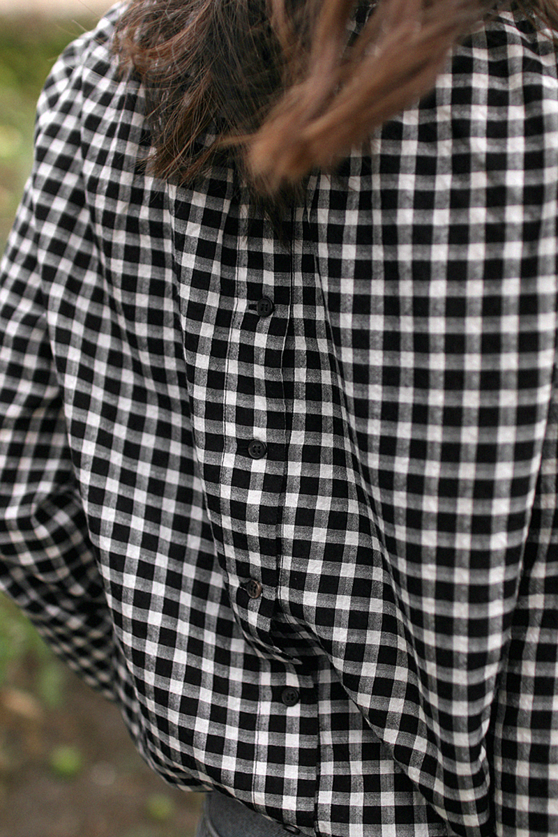 Nisi is wearing: Gingham pattern blouse, Gucci Princetown Slipper, Loewe Puzzle bag, mom jeans