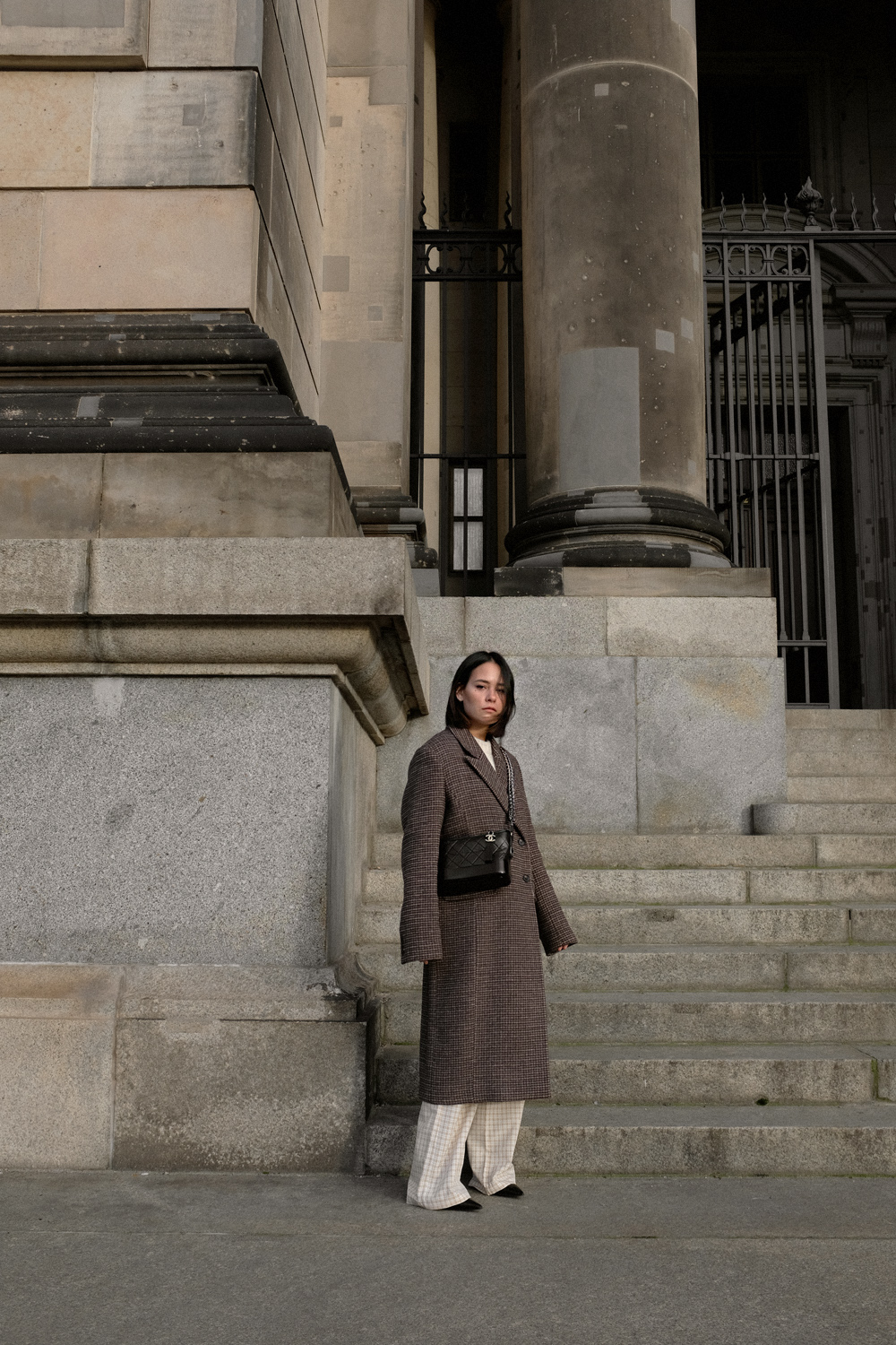 Nisi is wearing: Checkered coat LEVETE ROOM. Checkered trousers RÉSUMÉ. Embossed ankle boots ZIGN. Gabrielle bag CHANEL