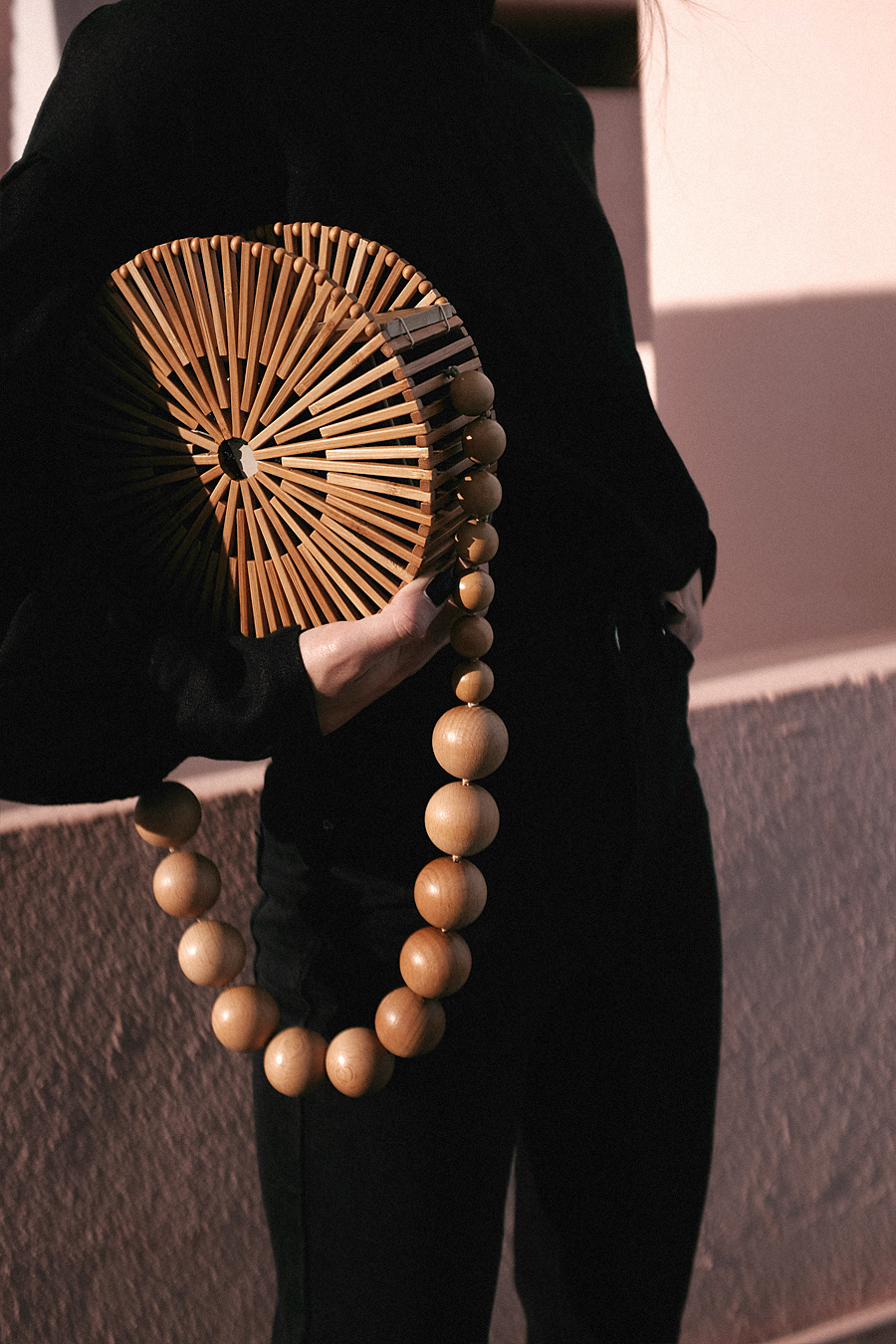 Outfit: Geometric Forms. Nisi is wearing: Cult Gaia Luna Bag, Manolo Blahnik Maysale Pumps, Mother-of-pearl earrings, Black mom jeans, Black high-neck blouse