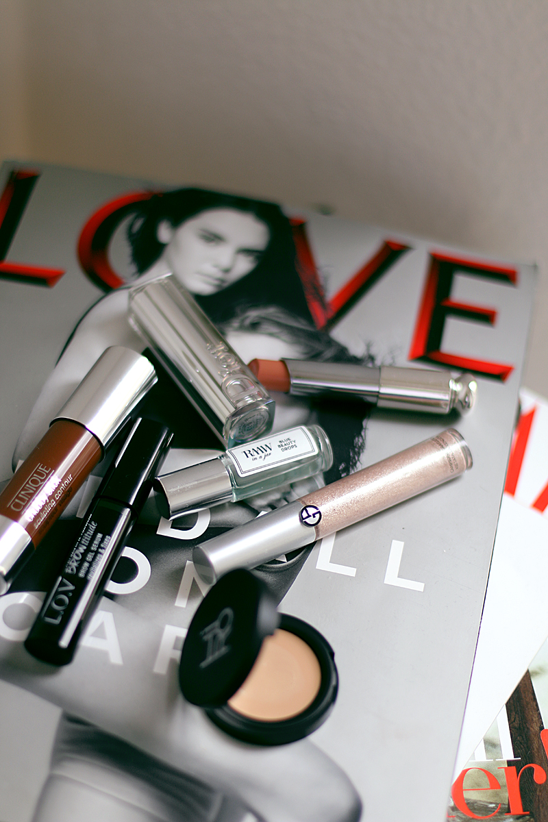 Dior Addict Lippenstift in Pause – Dior. Eye Tint Fluid Eye Shadow in 12 Gold Ashes – Giorgio Armani. Space Balm Concealer – Hiro. Eyeshadow in Naked – Urban Decay. Blue Beauty Drops Facial Oil – RAAW in a jar. Chubby Stick Sculpting Contour – Clinique. Brow Gel Serum – L.O.V.