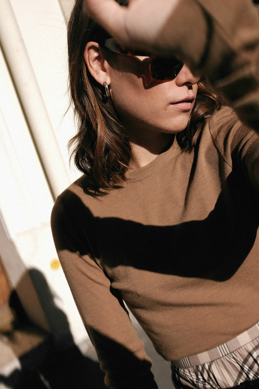 Nisi is wearing: Trenchcoat, Nanushka Belt bag, Manolo Blahnik Maysale mules, H&M Pleated skirt, Arket nude longsleeve top