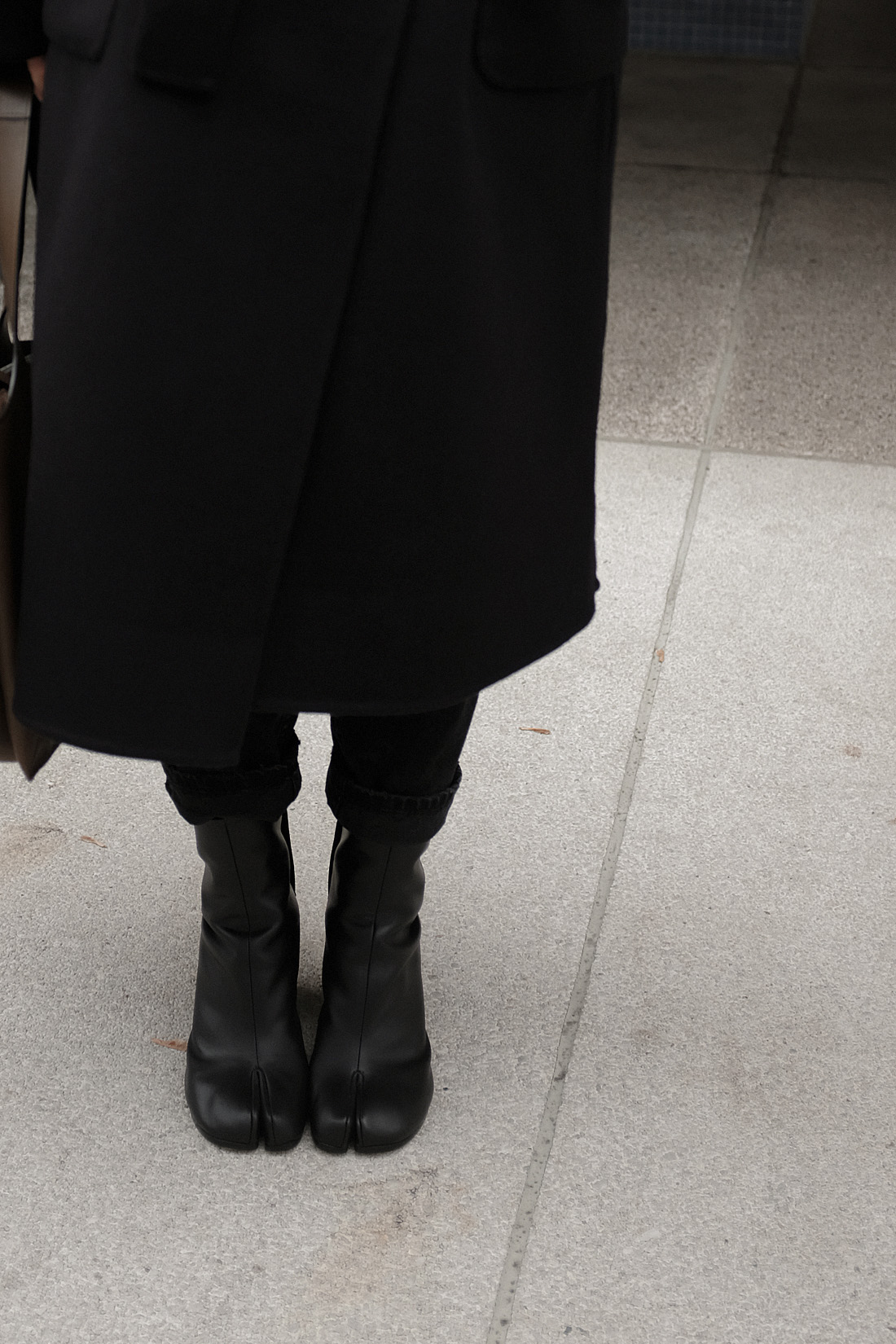 Desi is wearing: Maison Margiela Tabi boots, Céline Tri-Fold bag, Wrap coat, Knit jumper, Mom jeans L’Or Liquide maxi earrings by teetharejade