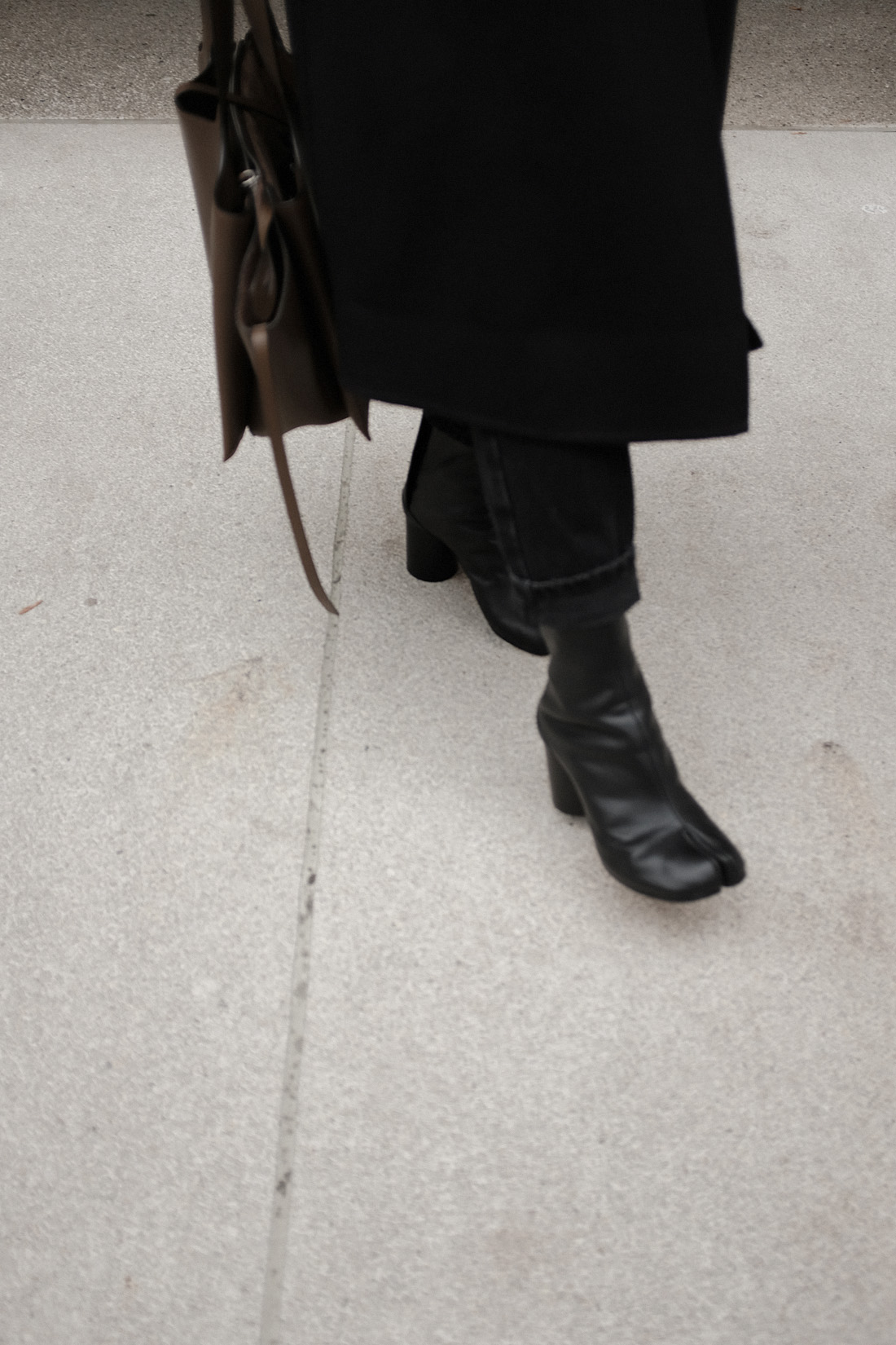 Desi is wearing: Maison Margiela Tabi boots, Céline Tri-Fold bag, Wrap coat, Knit jumper, Mom jeans L’Or Liquide maxi earrings by teetharejade