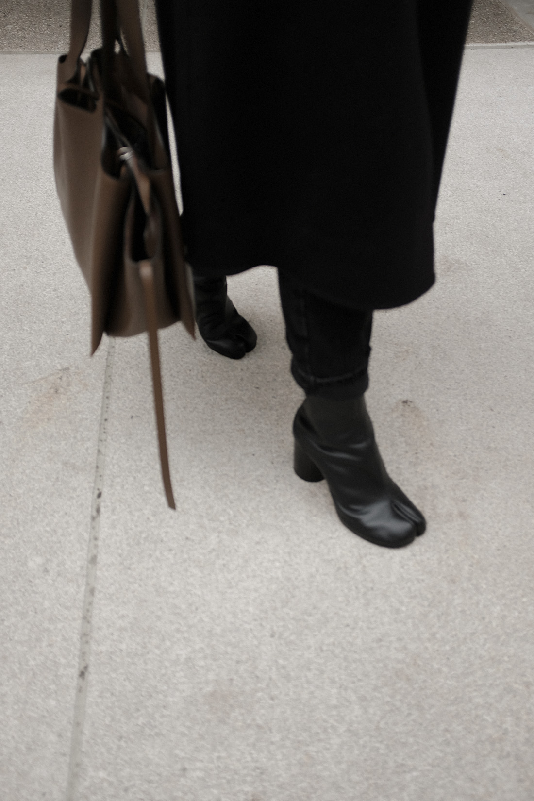 Desi is wearing: Maison Margiela Tabi boots, Céline Tri-Fold bag, Wrap coat, Knit jumper, Mom jeans L’Or Liquide maxi earrings by teetharejade