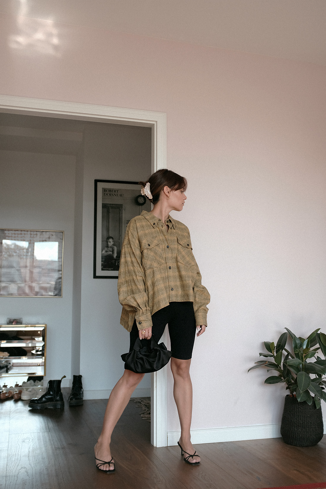 Nisi is wearing: Isabel Marant Etoile delora checked cotton shirt, cycling shorts, The Row Ascot bag, Alighieri jewelry, strappy sandals, crystal hair clip