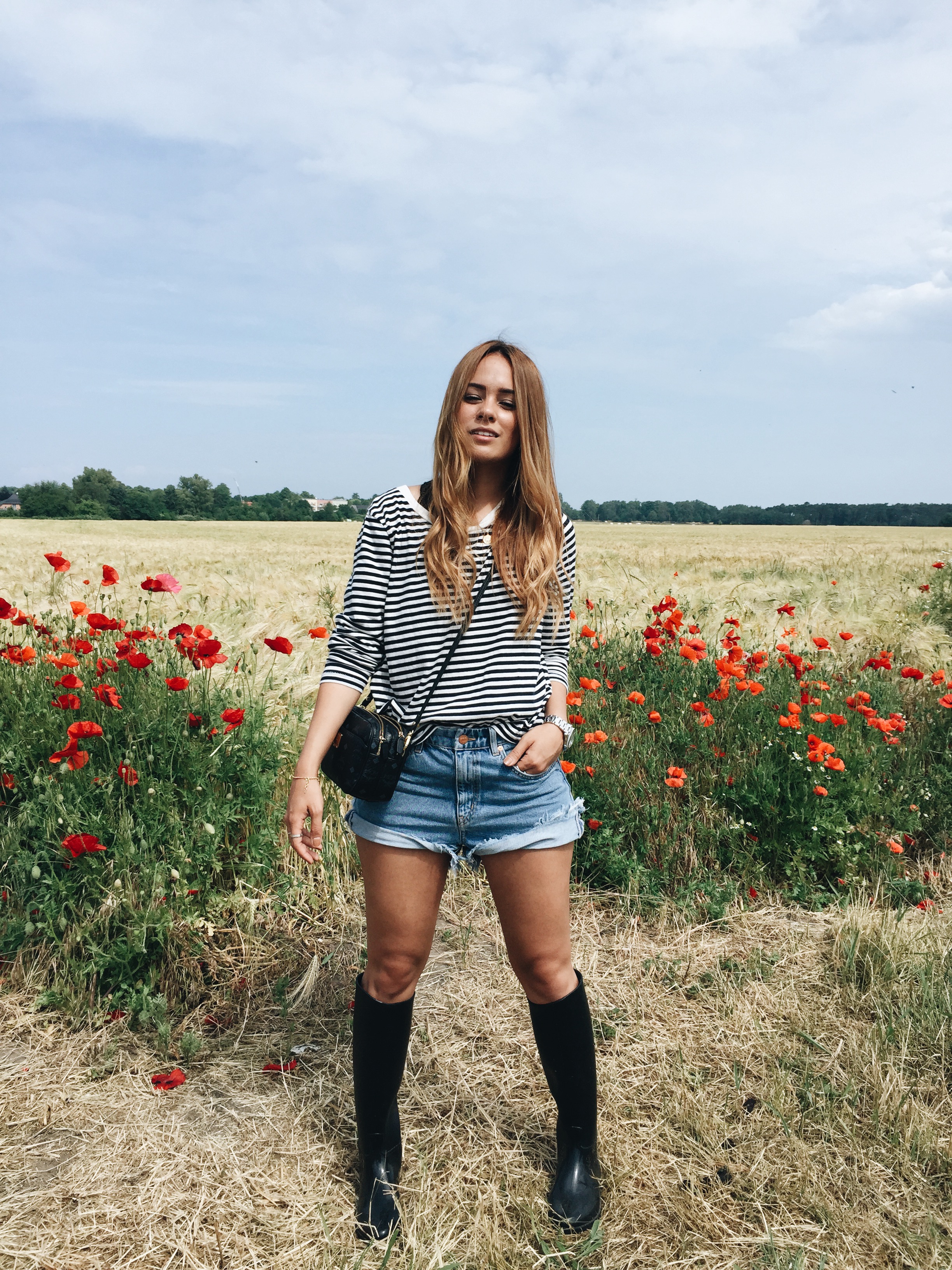 Desi is wearing Zara striped shirt, M.i.H. Jeans denim shorts, rubber boots, MCM bag