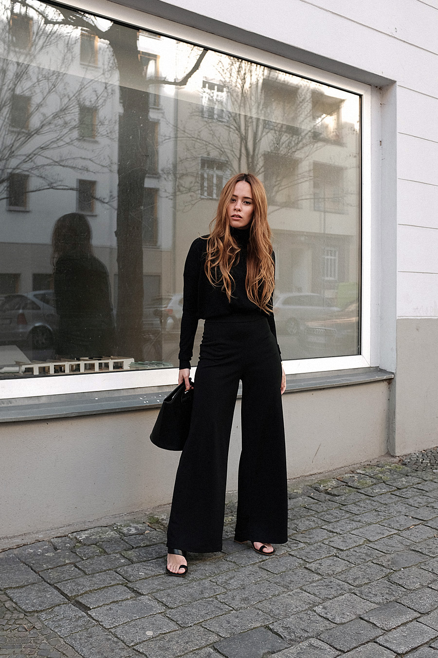 Outfit: All Black. Desi is wearing: Bucket bag, Wool turtleneck, toe mules, wide pants