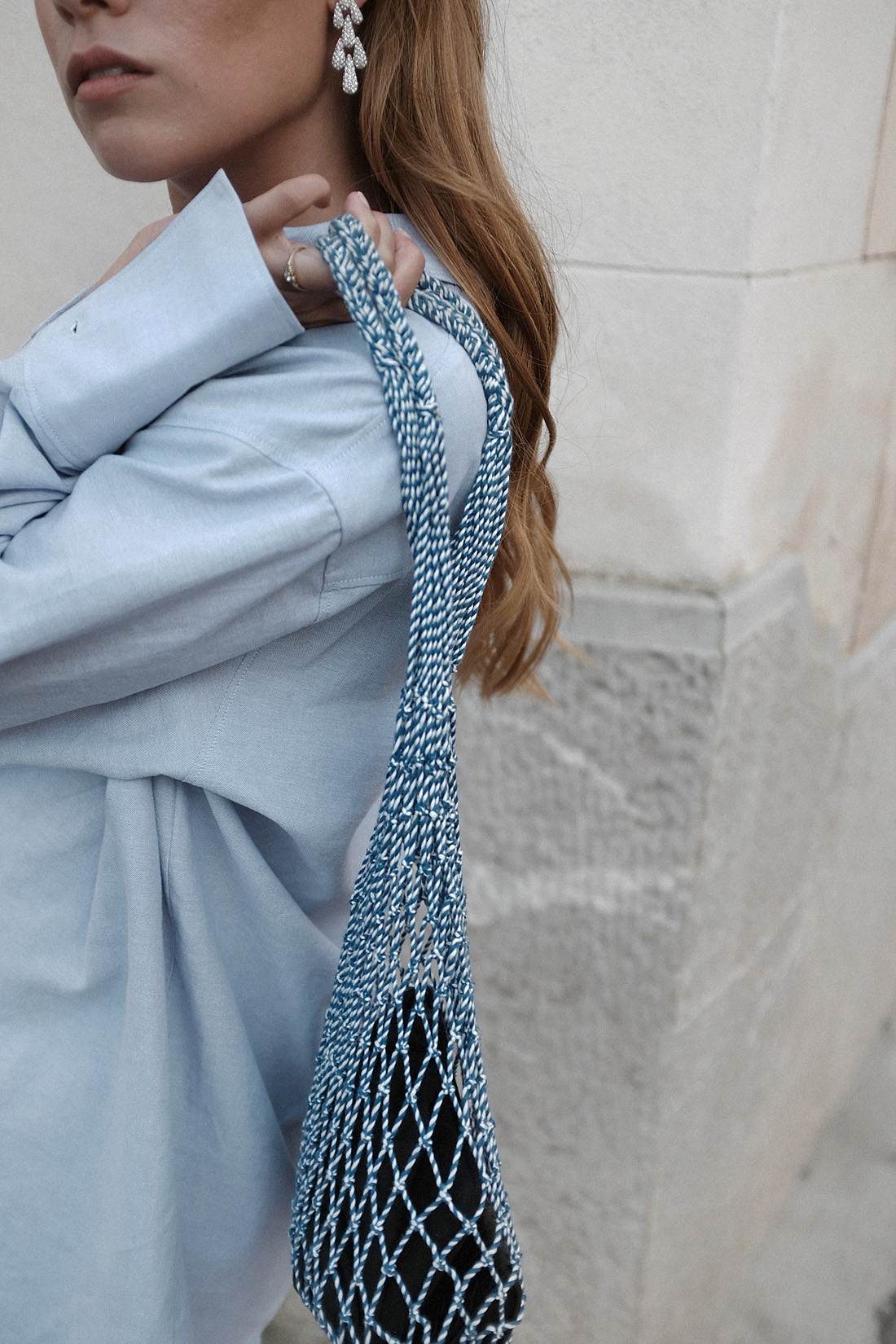 Desi is wearing: Hermès Oran Sandals, Oversized button down, Checked shorts, Céline Net bag, Vintage rhinestone earrings