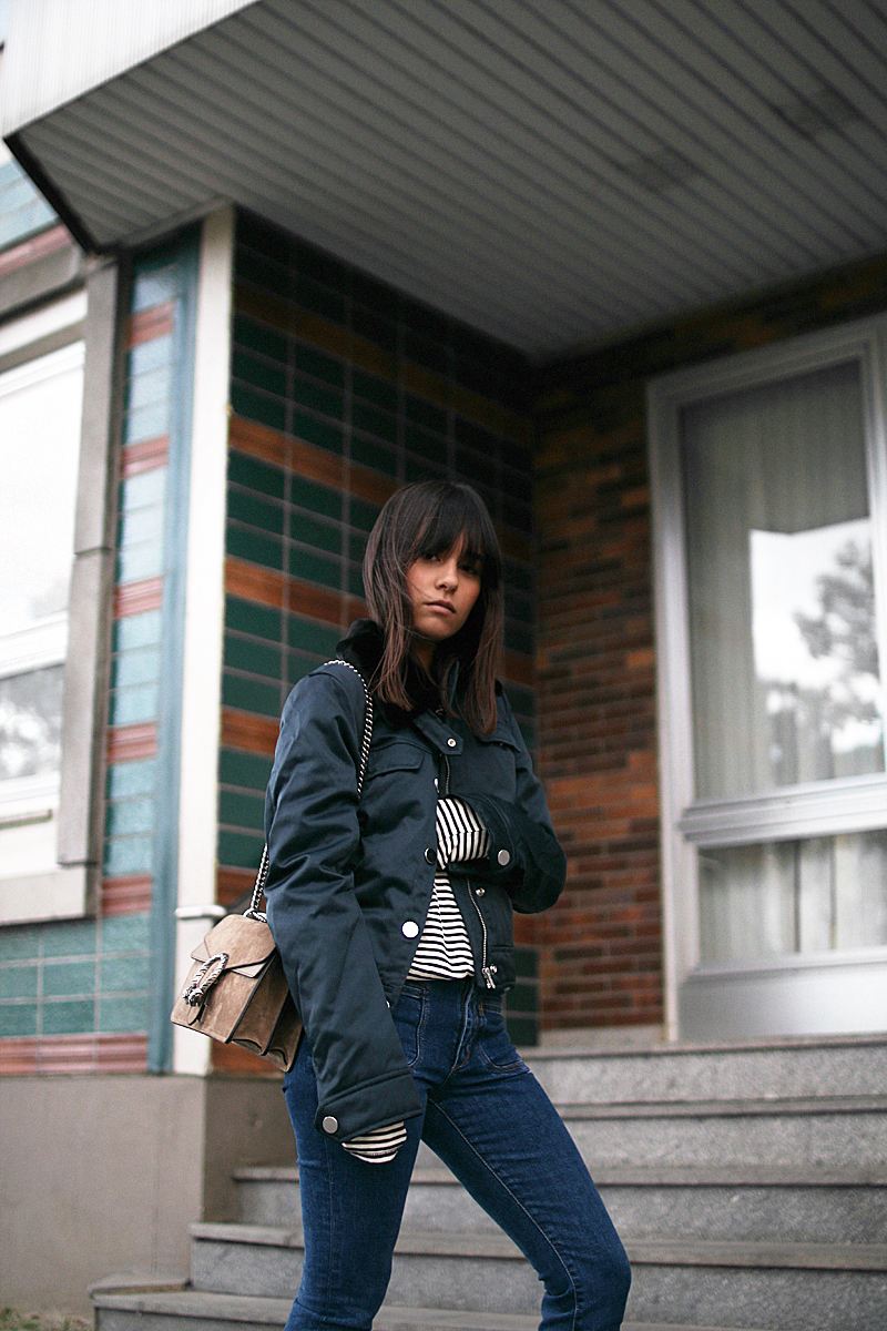 Nisi is wearing: Gucci Dionysus bag, Aviator jacket, Striped top, Flared denim jeans