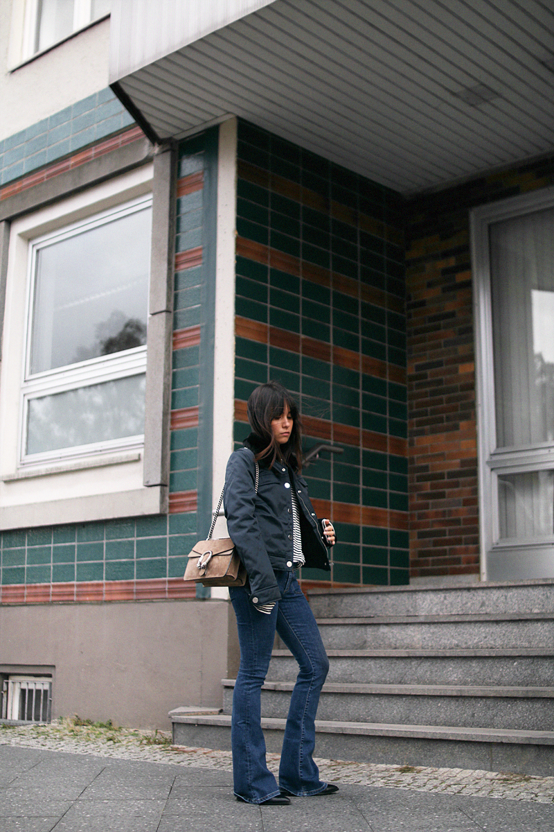 Nisi is wearing: Gucci Dionysus bag, Aviator jacket, Striped top, Flared denim jeans