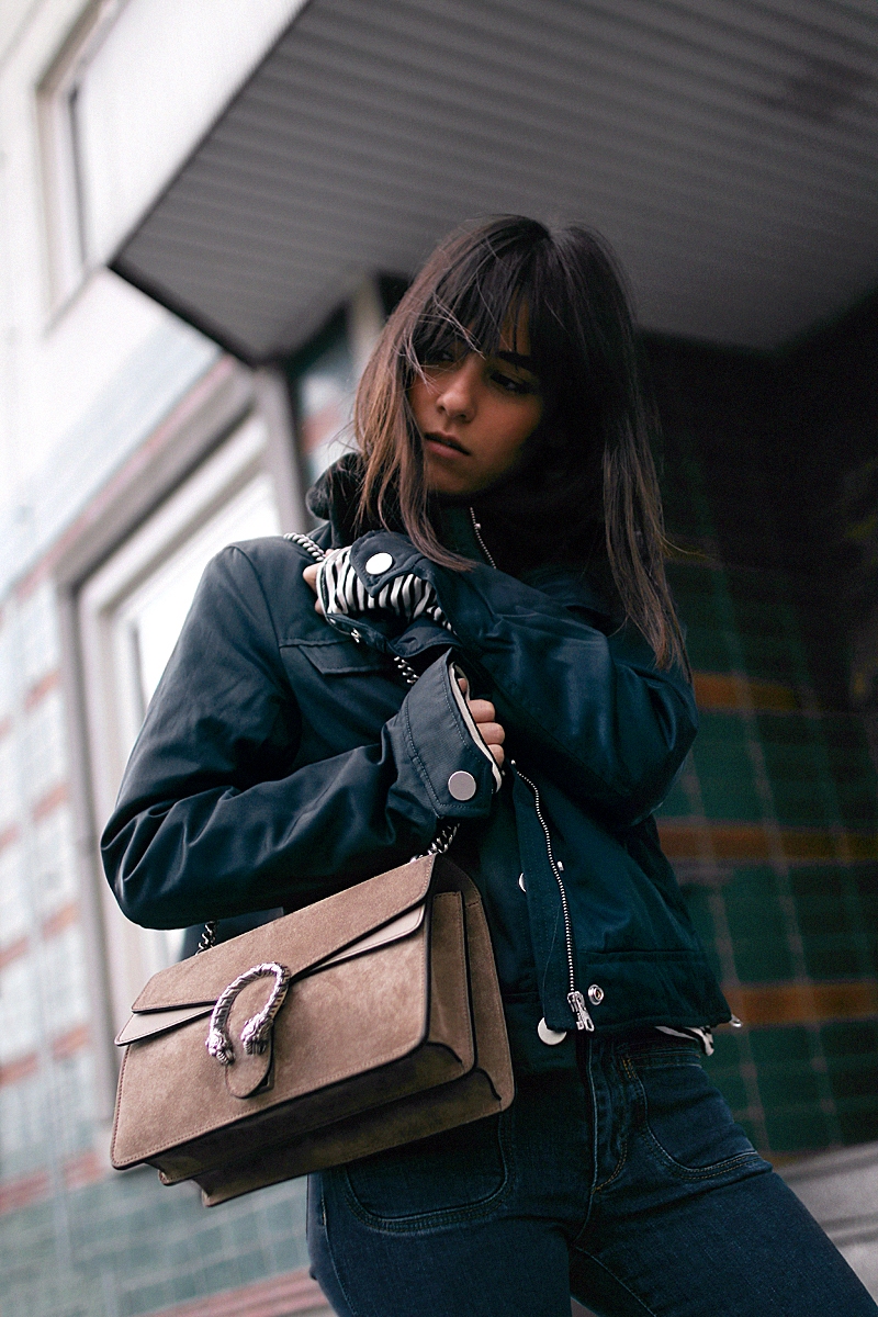 Nisi is wearing: Gucci Dionysus bag, Aviator jacket, Striped top, Flared denim jeans
