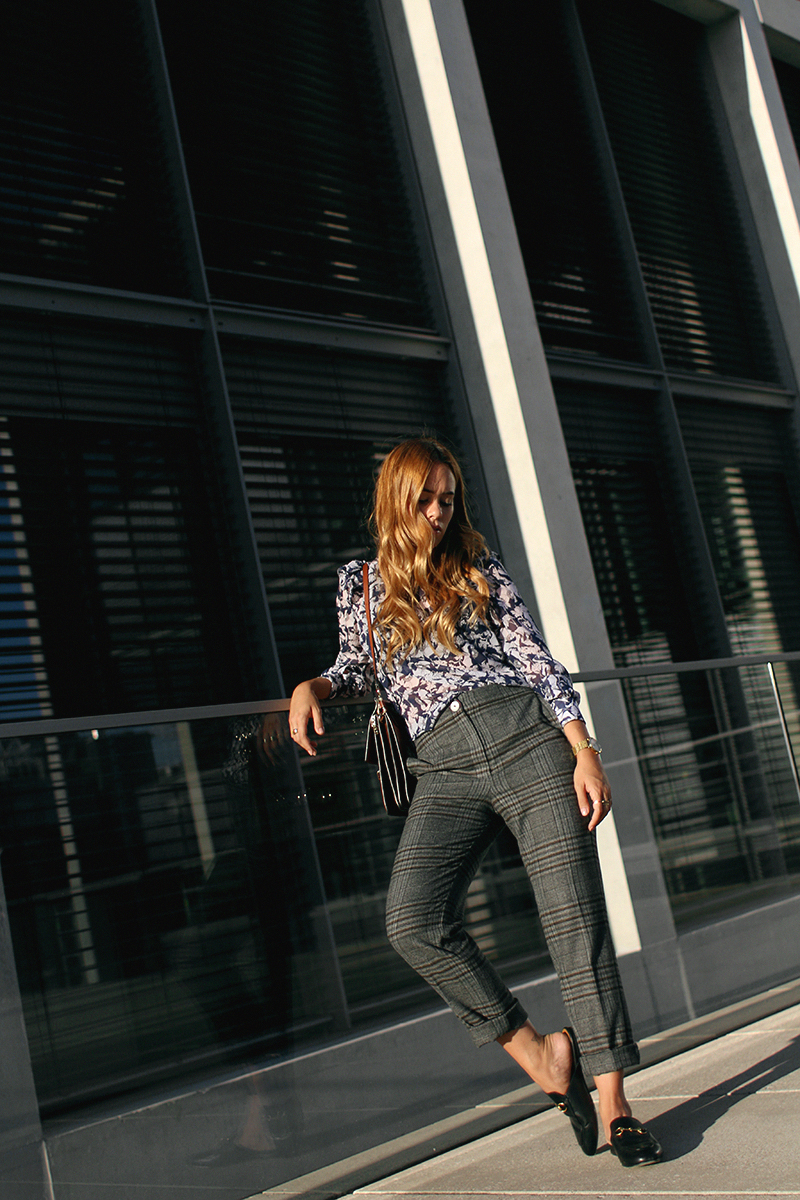 Desi is wearing: Mango checked trousers, Zara blouse, Gucci Princetown slippers, Chloé Faye bag.