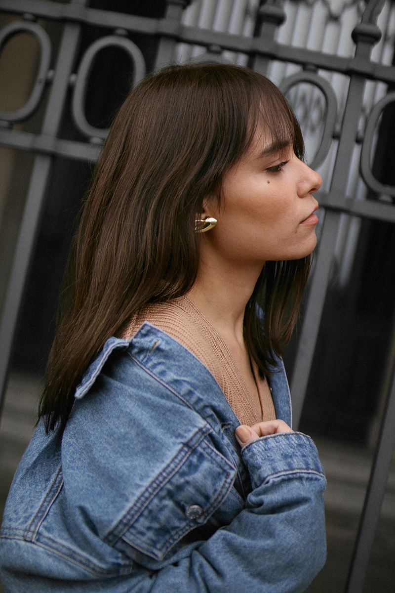 Nisi is wearing: Denim Jacket alla Balenciaga, Proenza Shoulder Hava bag, Python print boots, Cornelia Webb Earrings, Nude sweater, Black skinny jeans