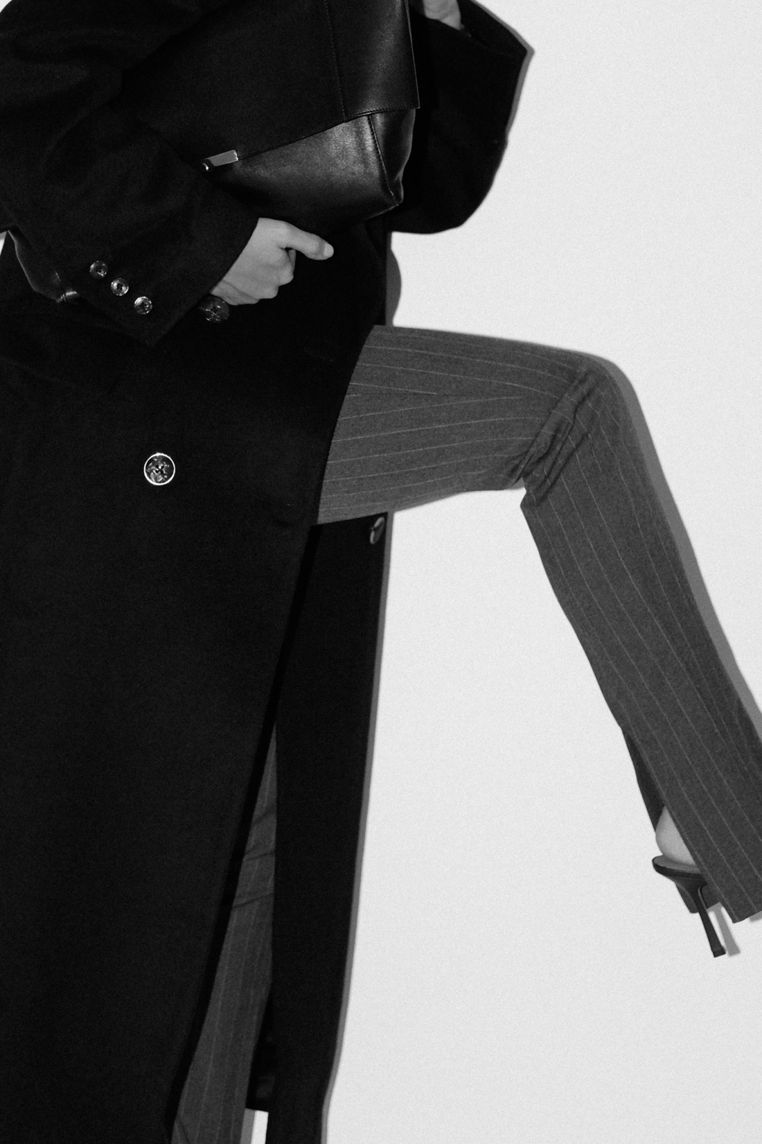 Desi wearing: Double breasted coat EDITED, Script-Logo sunglasses SAINT LAURENT, Silver hoops STILNEST, Pin-striped pants MANGO, Stretch mule sandals BOTTEGA VENETA, Big soft clutch CÉLINE, Silver watch KAPTEN & SON