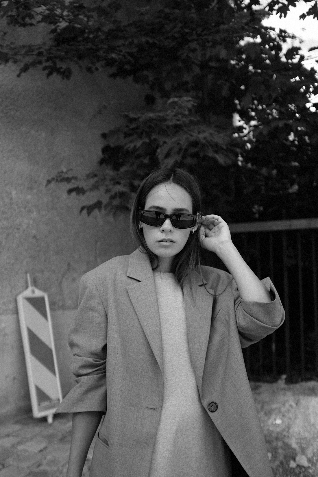 Desi is wearing: Oversized wool blazer – Arket, Maree t-Shirt dress – Edited, Script-Logo sunglasses – Saint Laurent, Devon bag – Boyy, Socks – Nike, 530 sneakers – New Balance