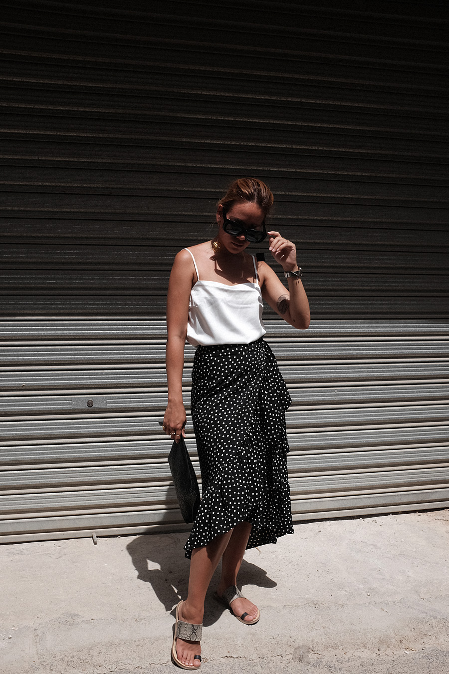 Desi is wearing: Jacquemus Le Carre spiral earrings, Loewe T Pouch, Celine Sunglasses, Vila Polka dot wrap skirt, Asos phyton sandals, Edited the Label Camisole