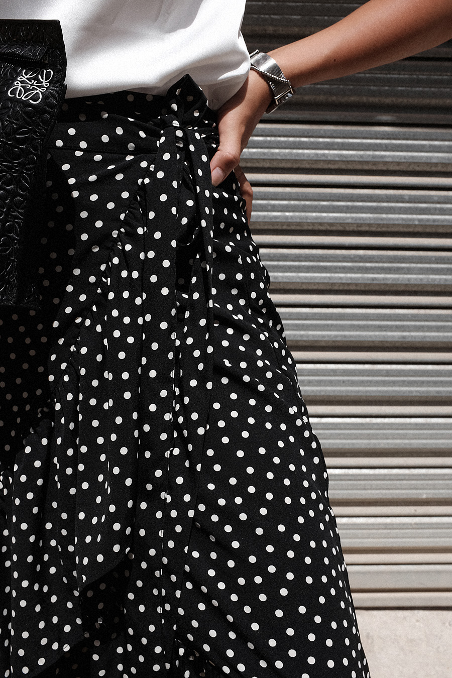 Desi is wearing: Jacquemus Le Carre spiral earrings, Loewe T Pouch, Celine Sunglasses, Vila Polka dot wrap skirt, Asos phyton sandals, Edited the Label Camisole