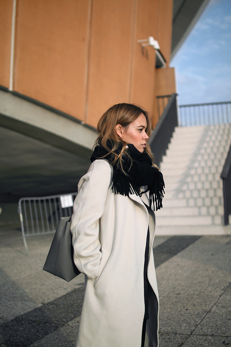 Outfit: Running Errands. Desi is wearing a Sandro wrap coat, Horizn Studios shopper, frill pants, Veja sneakers.