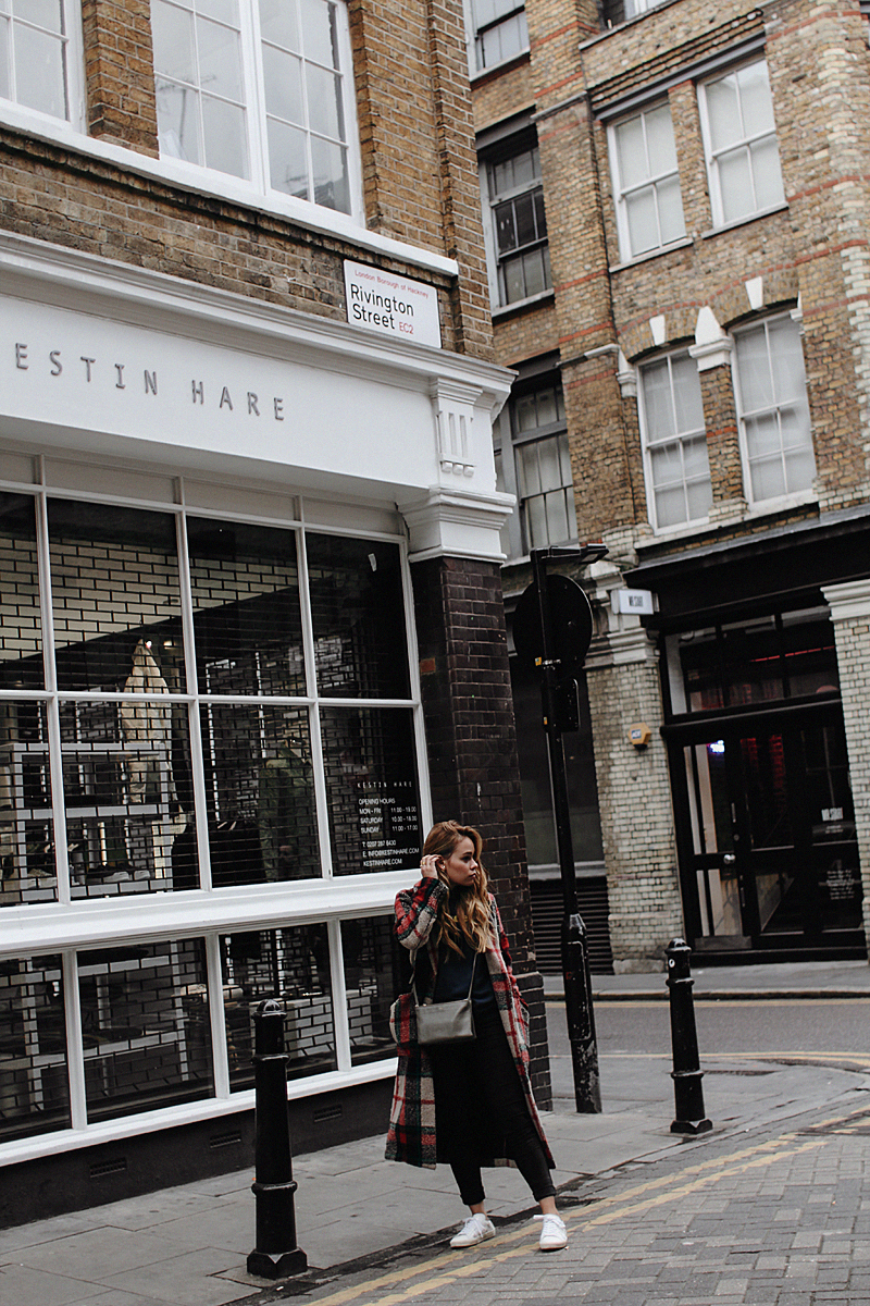 Desi is wearing: Céline Trio bag, print sweater, plaid coat, skinny jeans, Saint Laurent sneakers