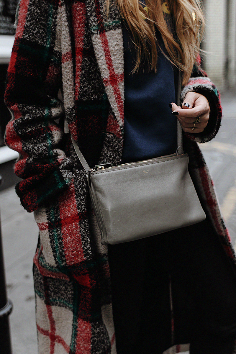 Desi is wearing: Céline Trio bag, print sweater, plaid coat, skinny jeans, Saint Laurent sneakers