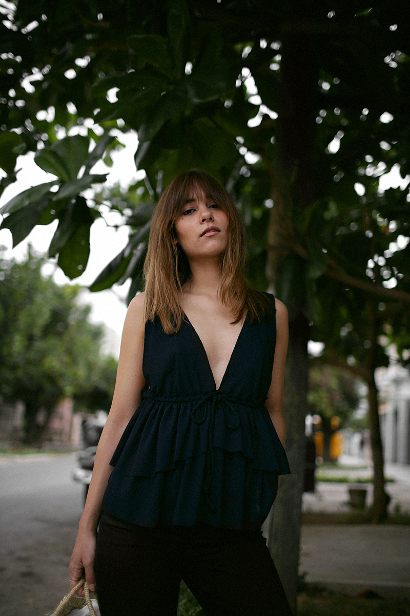 Nisi is wearing: See by Chloé top with ruffles, black denim mom jeans, ATP Atelier sandals, Straw bag, Rosefield gold mesh watch