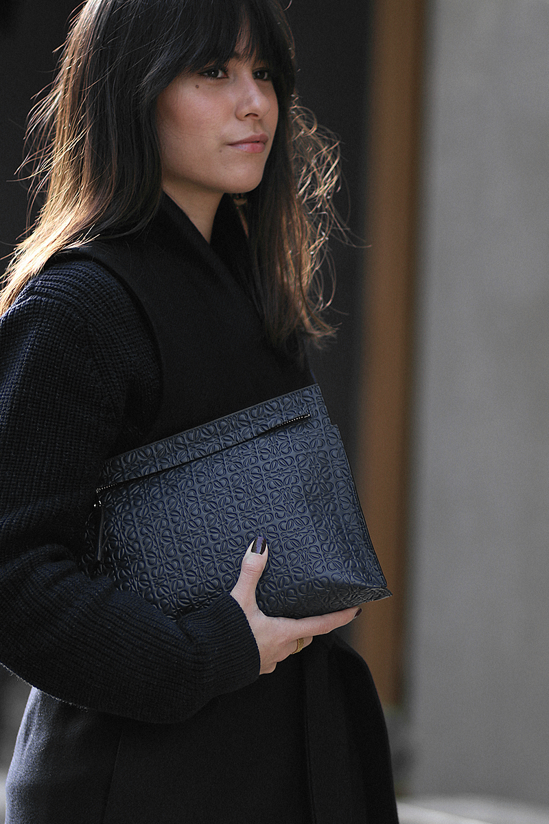 Nisi is wearing: Loewe T Pouch, Chloé Laurent ballet flats, wool vest, knit sweater, denim mom Jeans, statement earrings