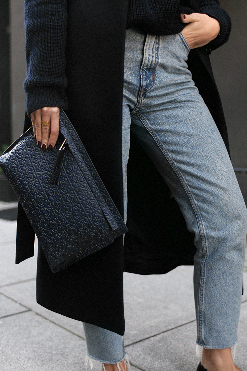 Nisi is wearing: Loewe T Pouch, Chloé Laurent ballet flats, wool vest, knit sweater, denim mom Jeans, statement earrings