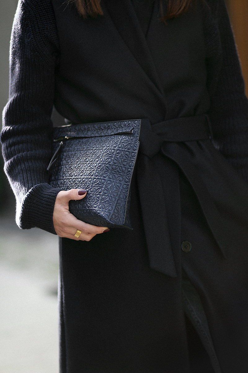 Nisi is wearing: Loewe T Pouch, Chloé Laurent ballet flats, wool vest, knit sweater, denim mom Jeans, statement earrings