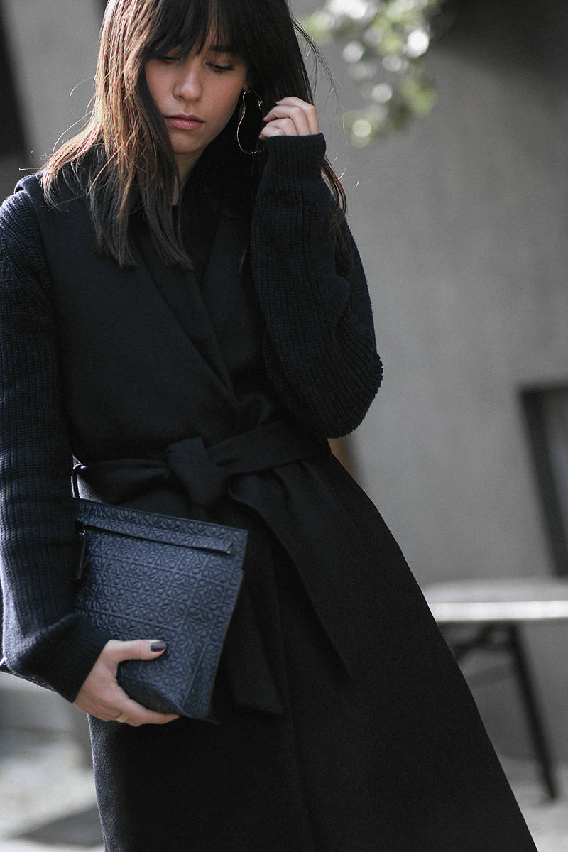 Nisi is wearing: Loewe T Pouch, Chloé Laurent ballet flats, wool vest, knit sweater, denim mom Jeans, statement earrings