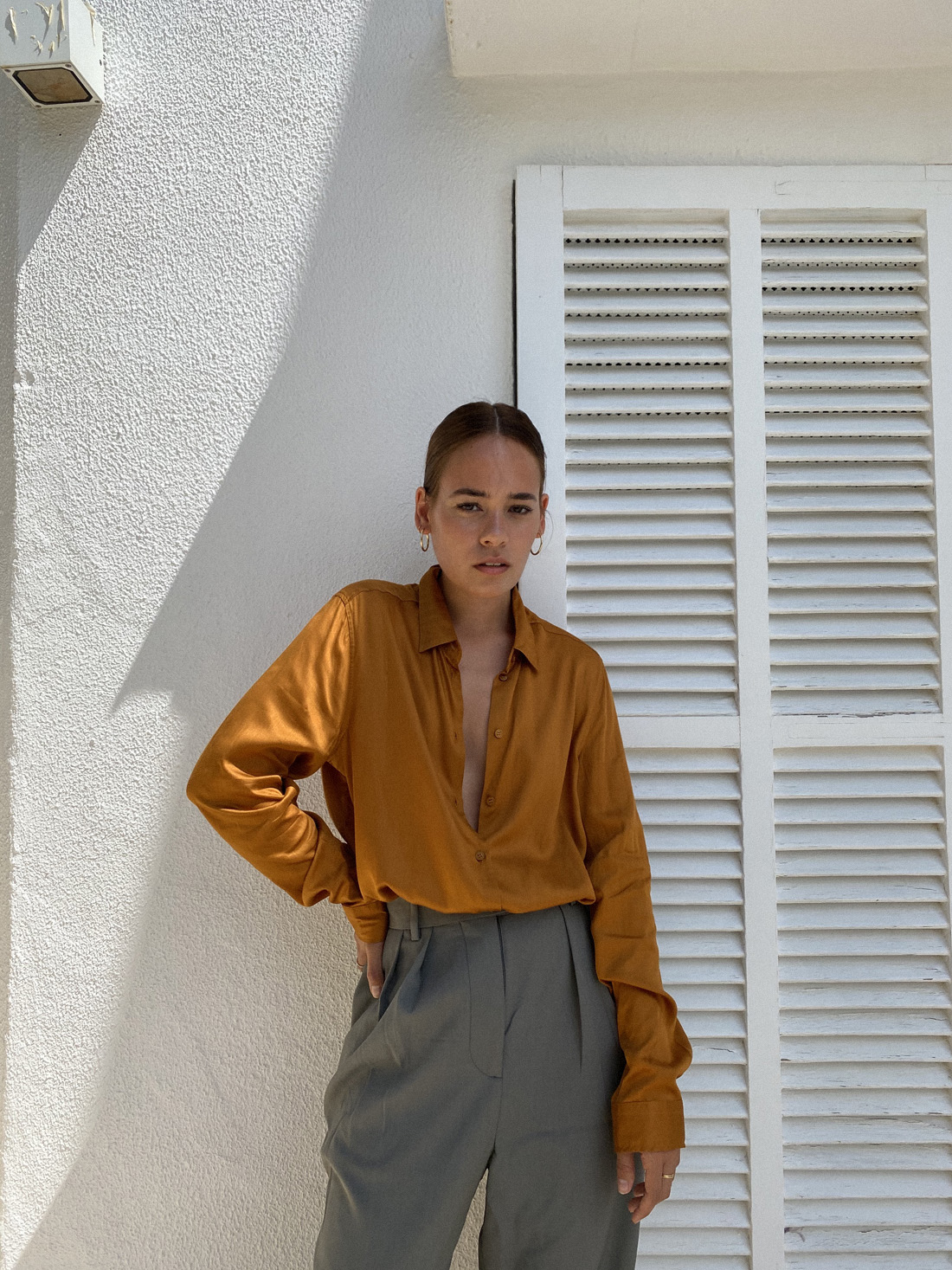 Desi is wearing: Hopsack trousers – Arket, Satin blouse – Seidensticker, Large hoops – Ohh Luilu, Flip flops – Havaianas