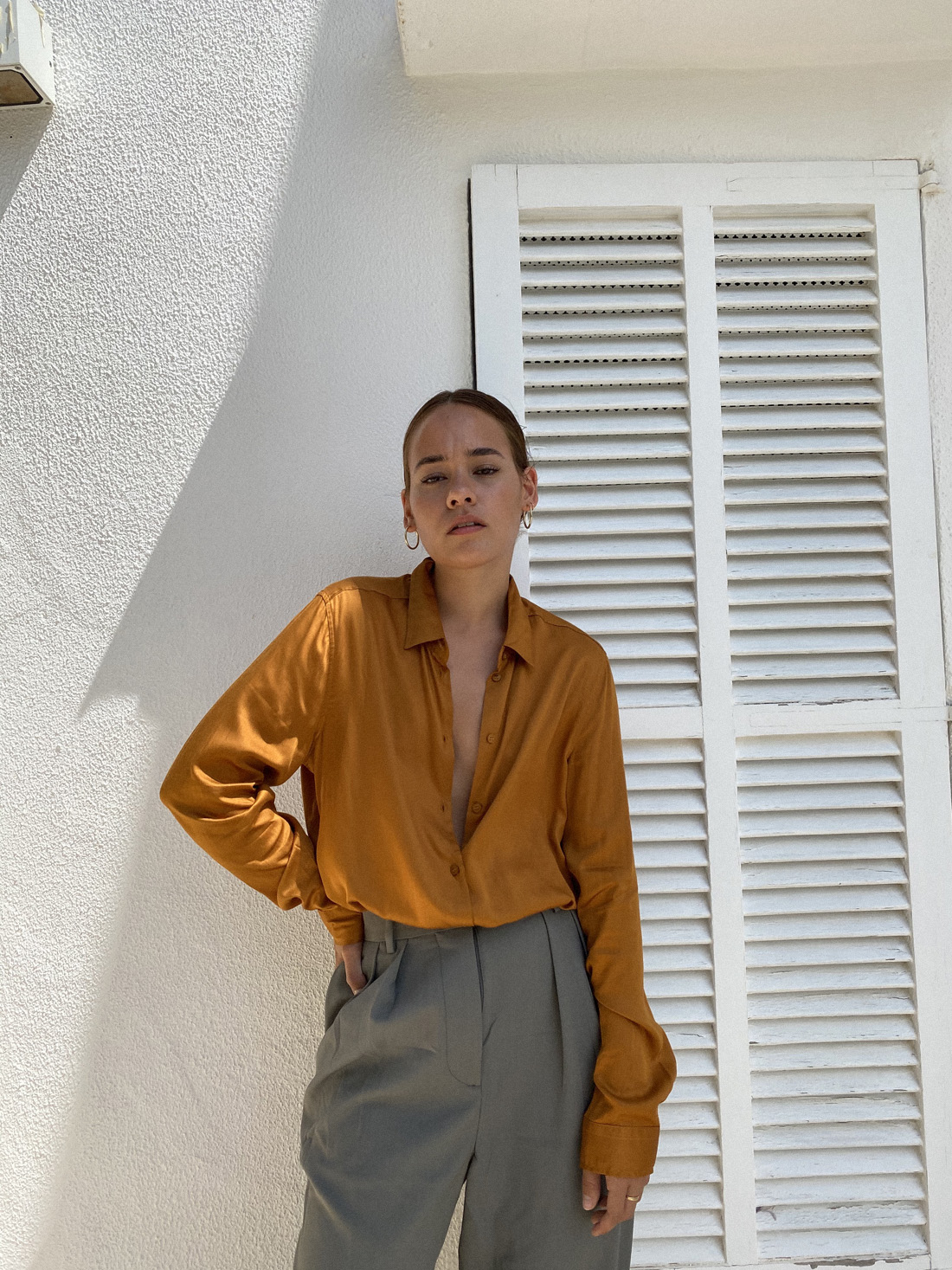 Desi is wearing: Hopsack trousers – Arket, Satin blouse – Seidensticker, Large hoops – Ohh Luilu, Flip flops – Havaianas