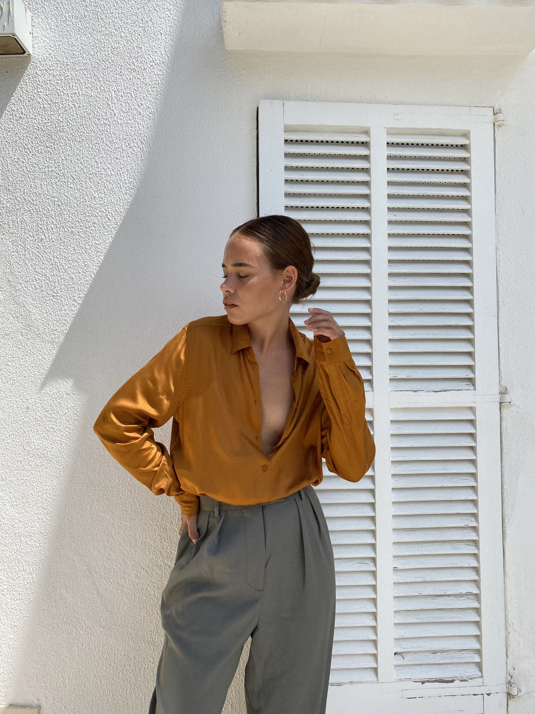 Desi is wearing: Hopsack trousers – Arket, Satin blouse – Seidensticker, Large hoops – Ohh Luilu, Flip flops – Havaianas
