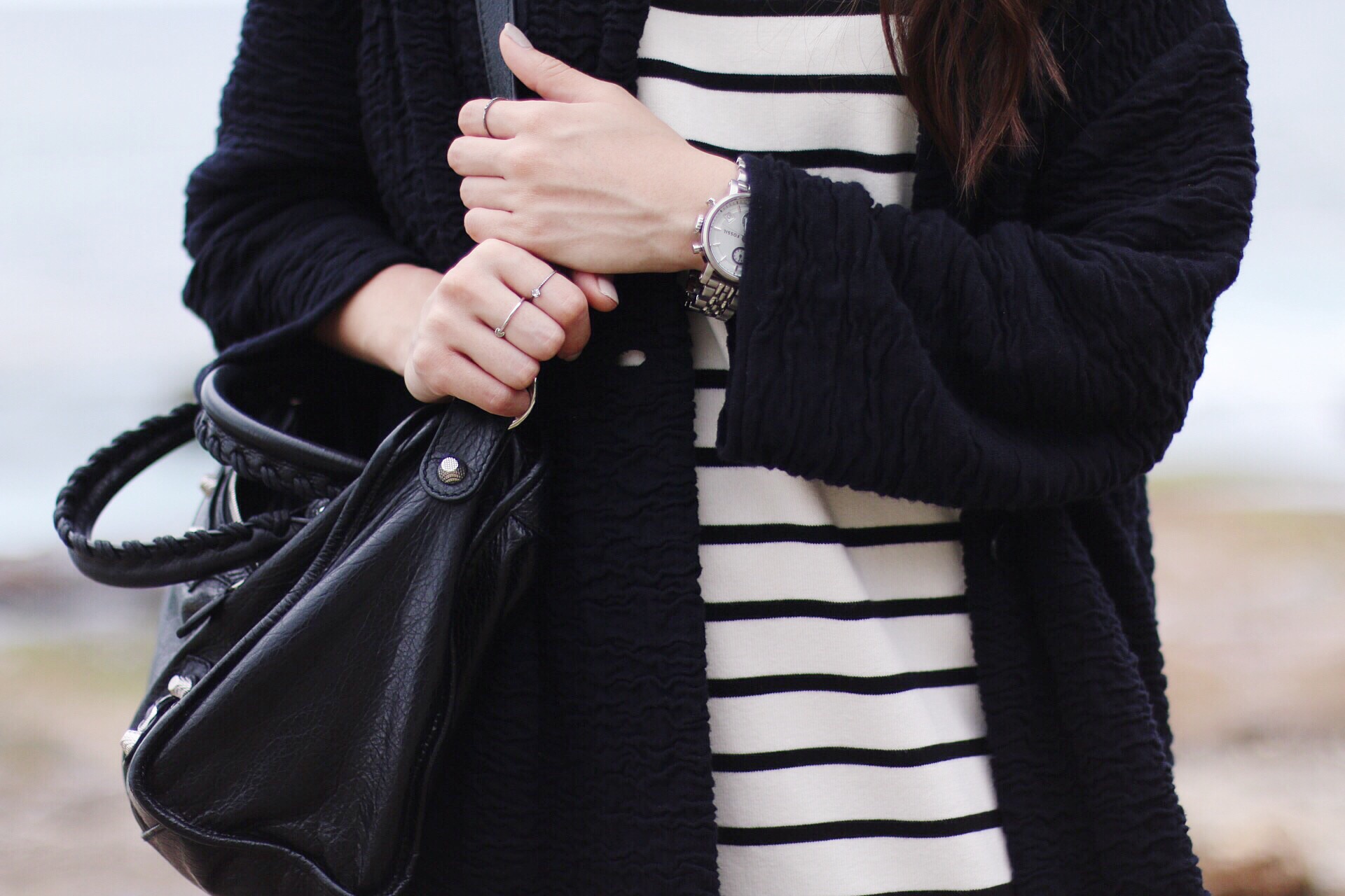 Nisi is wearing: Balenciaga Giant 12 City Bag, striped dress and an egg-shaped cardigan at Bondi Beach