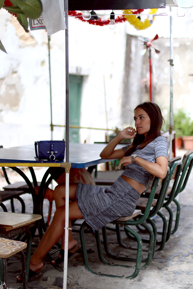 Nisi is wearing a knitted two piece from American Apparel, blue Givenchy Obsedia bag and yellow sunglasses from Komono
