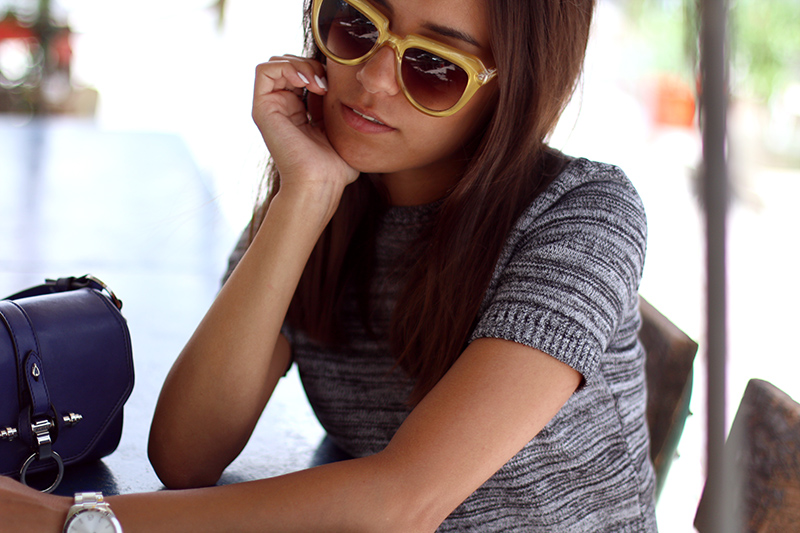 Nisi is wearing a knitted two piece from American Apparel, blue Givenchy Obsedia bag and yellow sunglasses from Komono