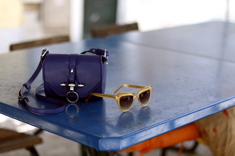 Nisi is wearing a knitted two piece from American Apparel, blue Givenchy Obsedia bag and yellow sunglasses from Komono